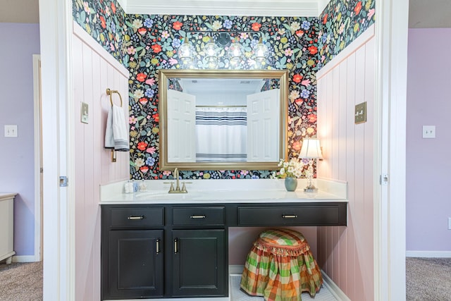 bathroom featuring vanity, baseboards, and wallpapered walls