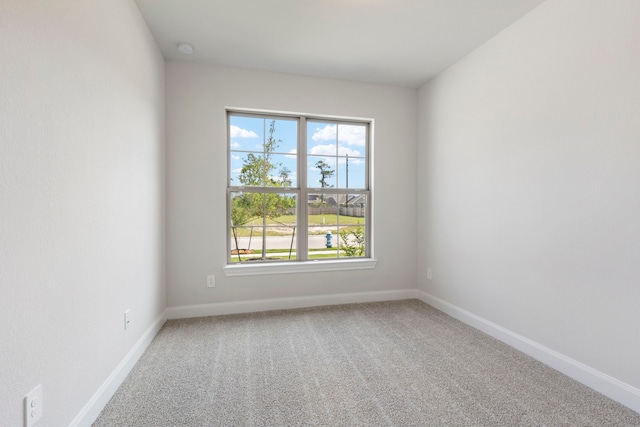 carpeted spare room featuring baseboards