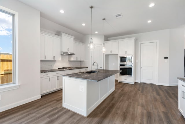 kitchen with dark wood-style floors, visible vents, a sink, stainless steel appliances, and tasteful backsplash