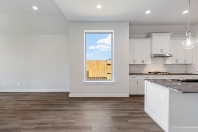 kitchen featuring tasteful backsplash, dark wood-type flooring, stainless steel gas cooktop, under cabinet range hood, and white cabinets