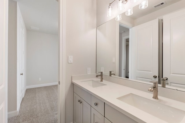 full bath with a sink, visible vents, baseboards, and double vanity