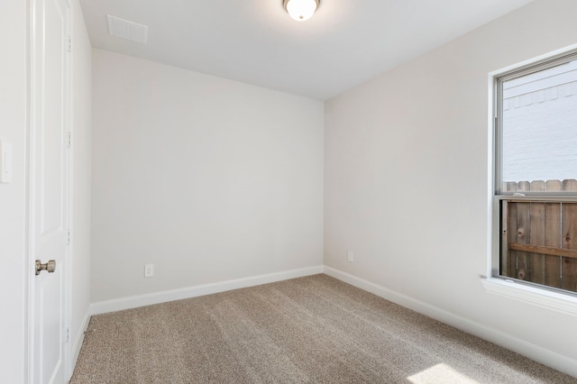 unfurnished room with visible vents, baseboards, and carpet floors