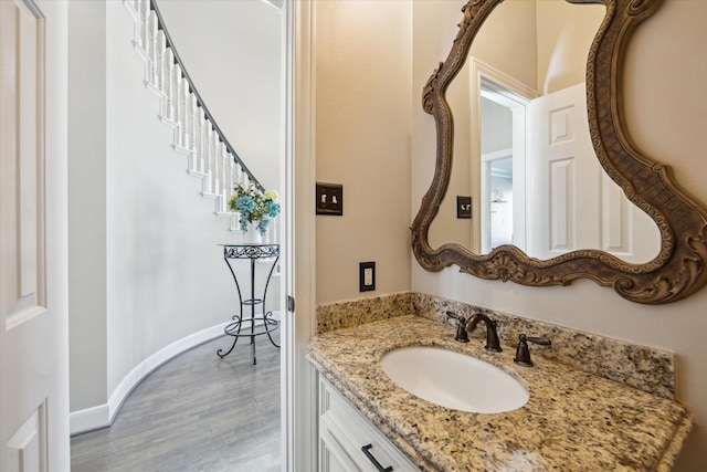 bathroom with baseboards, wood finished floors, and vanity