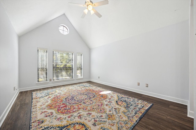 spare room with dark wood-type flooring, ceiling fan, high vaulted ceiling, and baseboards