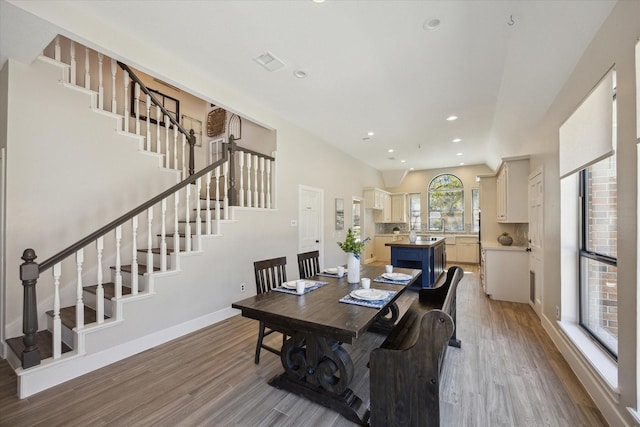 dining space featuring stairway, baseboards, wood finished floors, and recessed lighting