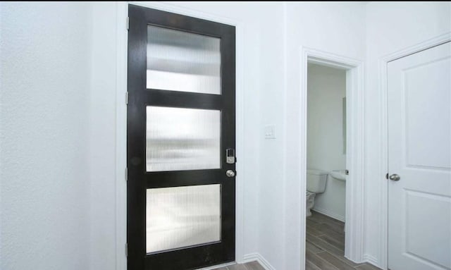 foyer entrance with wood finish floors and baseboards