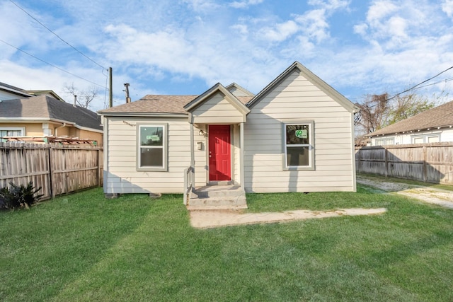 view of front facade with a fenced backyard and a front yard