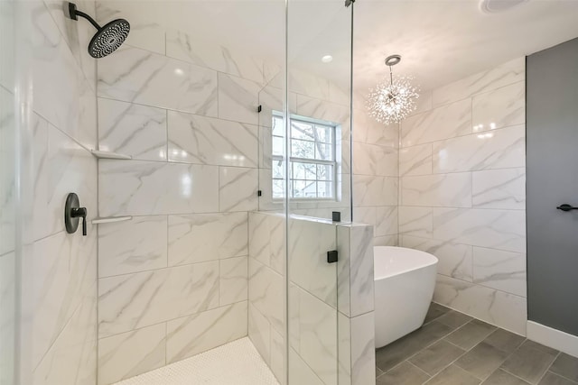 bathroom with a freestanding bath, a stall shower, and a chandelier