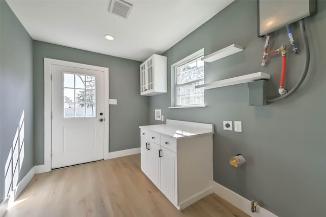 laundry room featuring a healthy amount of sunlight, light wood finished floors, and electric dryer hookup