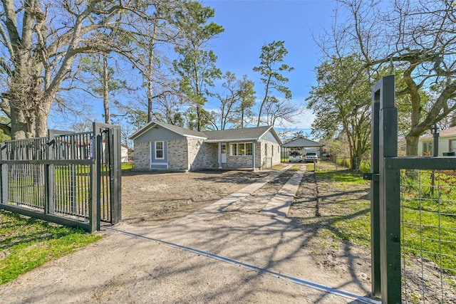 view of front of property with driveway, fence, and a gate