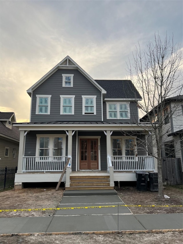 view of front of house with french doors, a porch, and fence