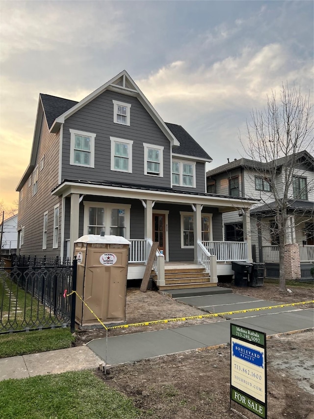 view of front of house with covered porch and fence