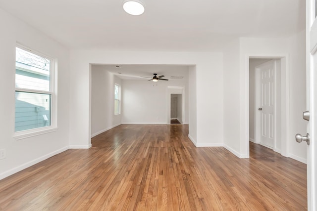 unfurnished room with light wood-type flooring, plenty of natural light, and baseboards