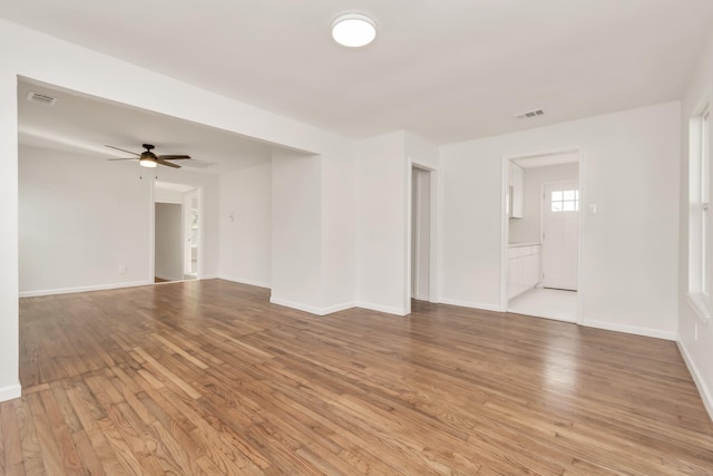 unfurnished room featuring light wood-type flooring, baseboards, visible vents, and ceiling fan