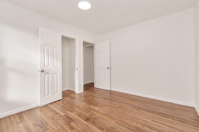 unfurnished bedroom with light wood-type flooring and baseboards