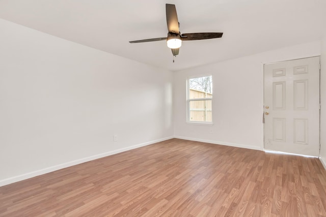 unfurnished room with ceiling fan, light wood finished floors, and baseboards