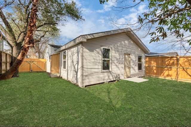 back of house featuring a fenced backyard and a yard