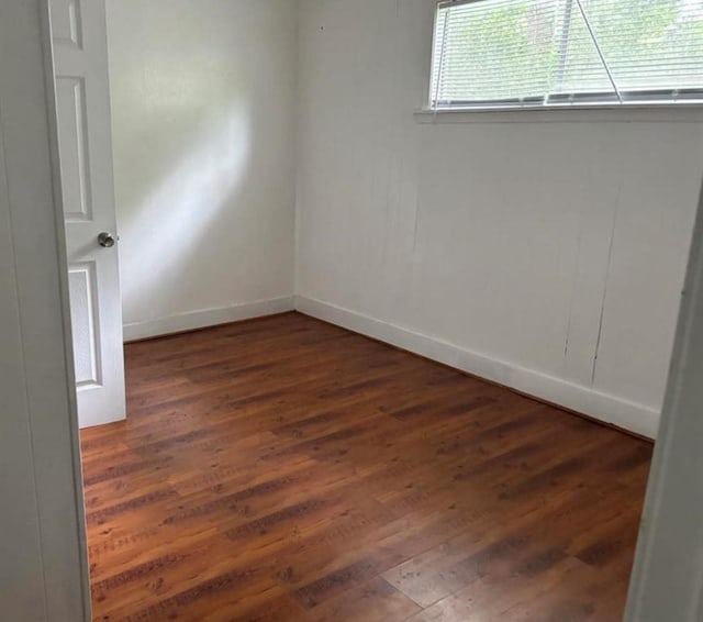 unfurnished room with baseboards and wood finished floors