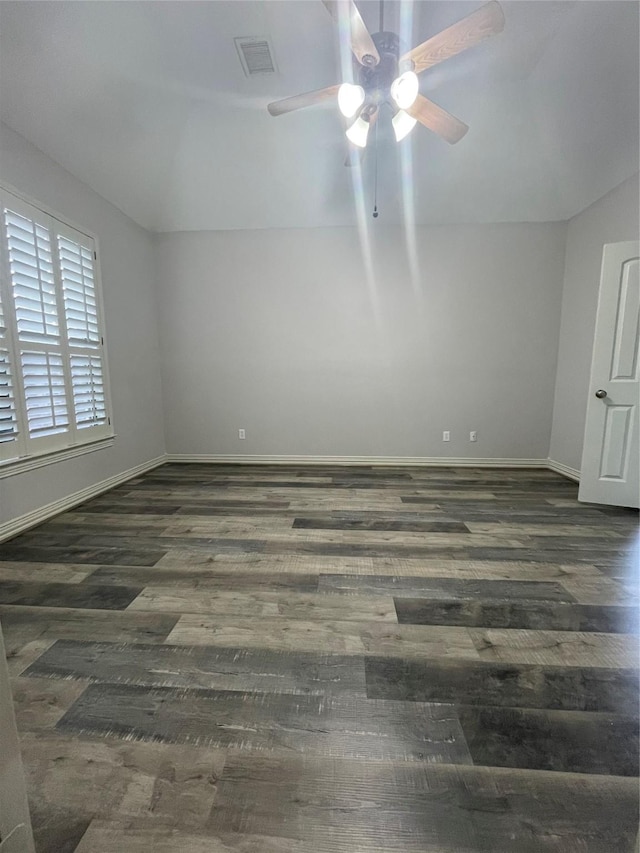 empty room featuring visible vents, ceiling fan, baseboards, and wood finished floors