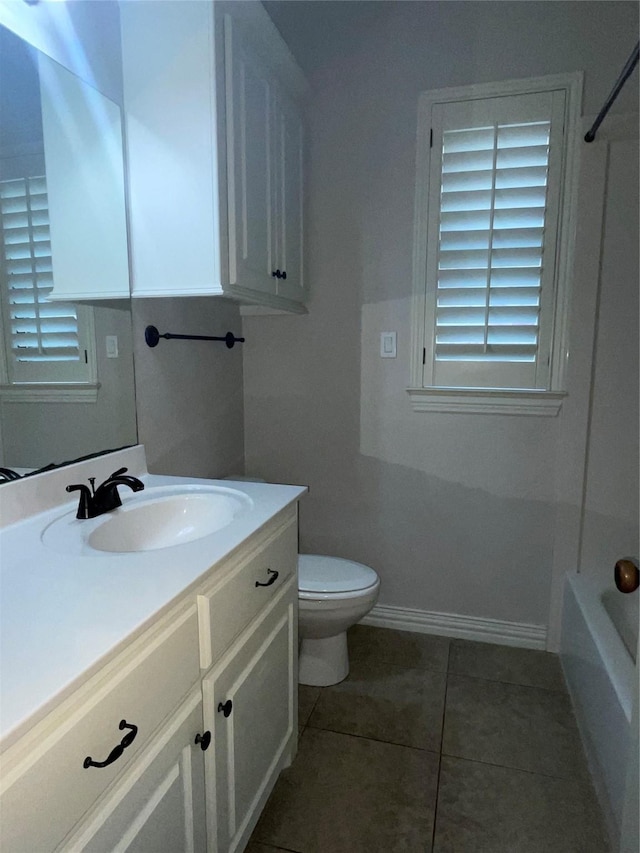 full bath featuring baseboards, toilet, tile patterned floors, a bathtub, and vanity