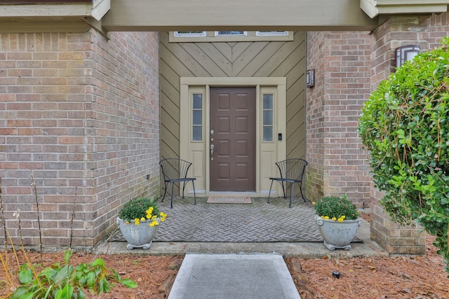 entrance to property featuring brick siding