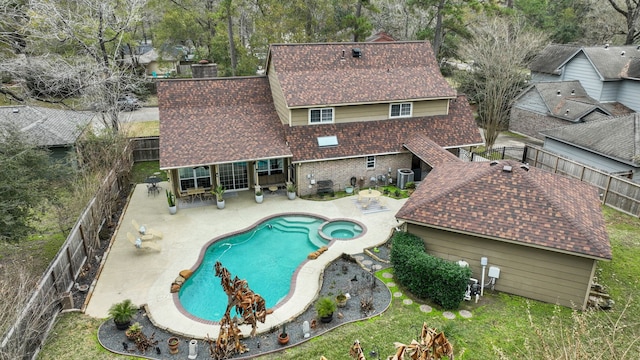 view of pool featuring a patio, a fenced backyard, cooling unit, a yard, and a pool with connected hot tub