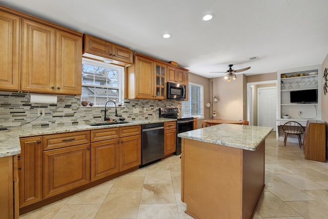 kitchen with dishwashing machine, light stone counters, a sink, electric stove, and brown cabinetry