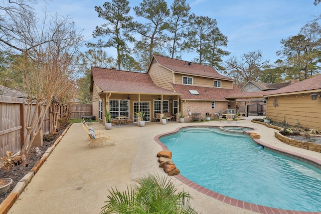 view of pool featuring a fenced backyard, a pool with connected hot tub, a ceiling fan, and a patio