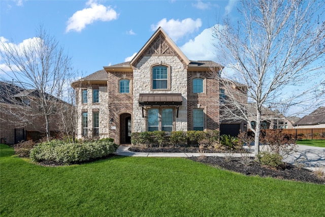 french country style house featuring a garage, brick siding, driveway, stone siding, and a front lawn