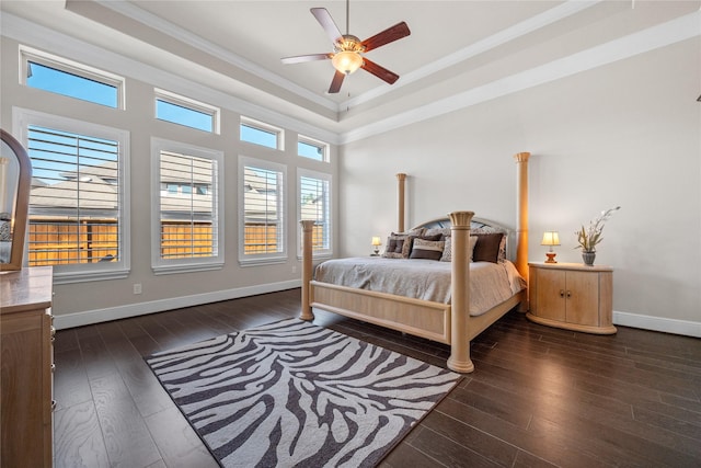 bedroom with baseboards, a raised ceiling, a ceiling fan, hardwood / wood-style floors, and crown molding