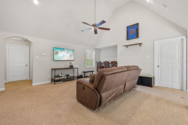 living area with light carpet, high vaulted ceiling, arched walkways, and visible vents