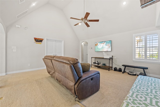 living room with light carpet, arched walkways, baseboards, ceiling fan, and high vaulted ceiling