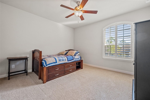 bedroom with a ceiling fan, light carpet, and baseboards