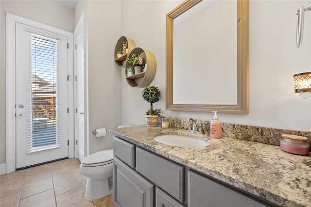 bathroom with toilet, tile patterned flooring, and vanity