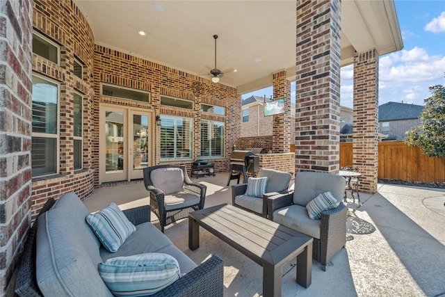 view of patio with fence, an outdoor hangout area, and a ceiling fan