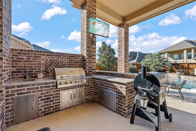 view of patio / terrace with a sink, a fenced backyard, area for grilling, and a grill