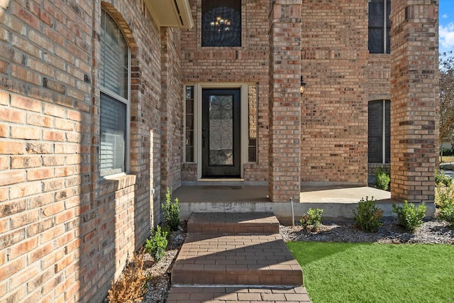 doorway to property with brick siding