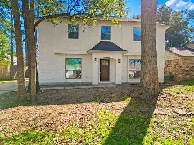 view of front of house featuring brick siding, board and batten siding, and fence