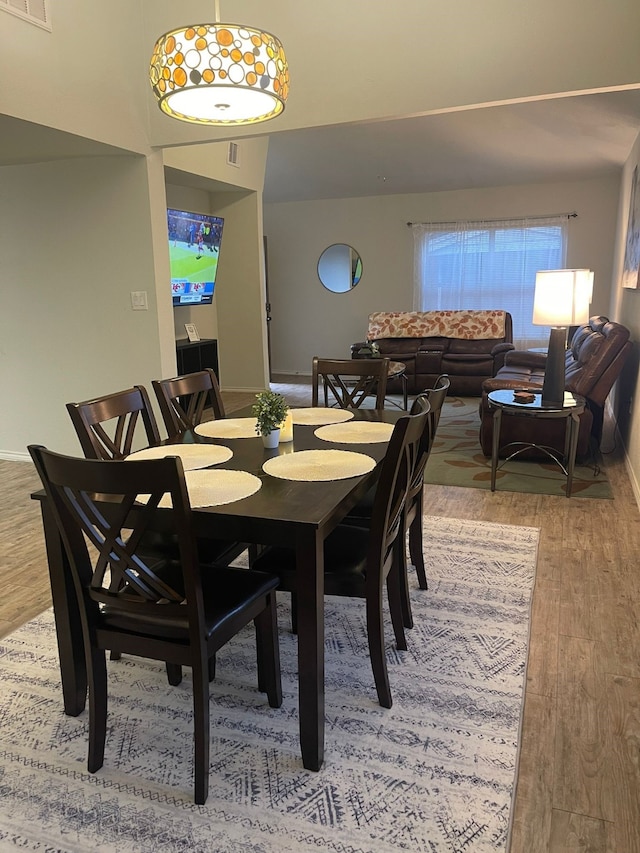 dining room with wood finished floors, visible vents, and baseboards