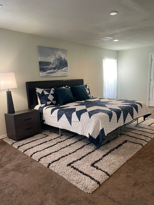 carpeted bedroom with a textured ceiling, visible vents, and recessed lighting