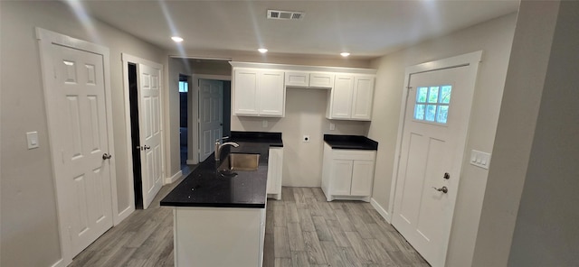 716 Alamo St, Rosenberg, TX 77471 - kitchen featuring a sink, white cabinets, light wood-style floors, dark countertops, and recessed lighting