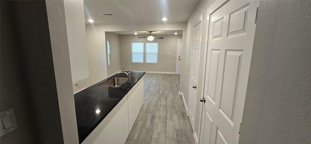 716 Alamo St, Rosenberg, TX 77471 - hallway featuring a sink, light wood finished floors, a textured wall, recessed lighting, and baseboards