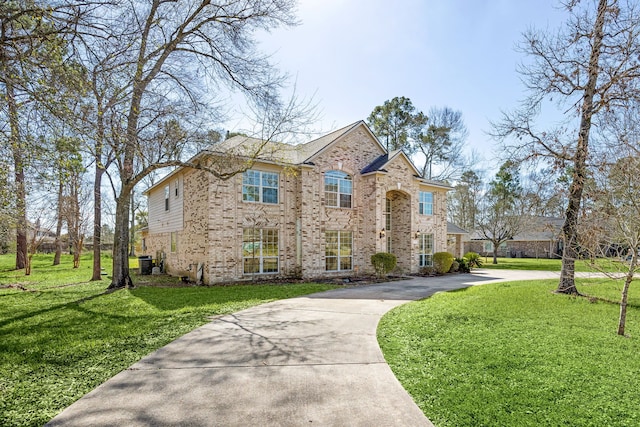 view of front of property featuring driveway, a front lawn, and brick siding