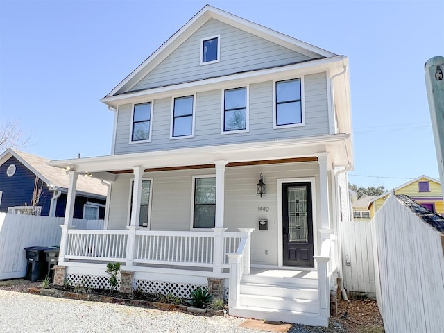 traditional style home with covered porch and fence