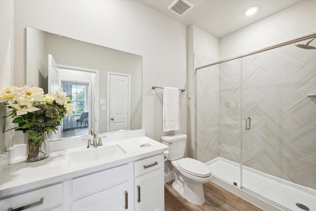 full bathroom with vanity, wood finished floors, visible vents, a stall shower, and toilet