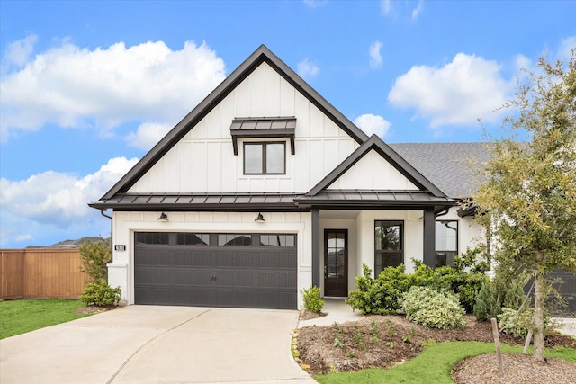 modern inspired farmhouse with a standing seam roof, fence, board and batten siding, concrete driveway, and metal roof