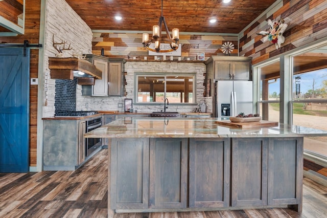 kitchen with wooden ceiling, a barn door, plenty of natural light, and stainless steel appliances