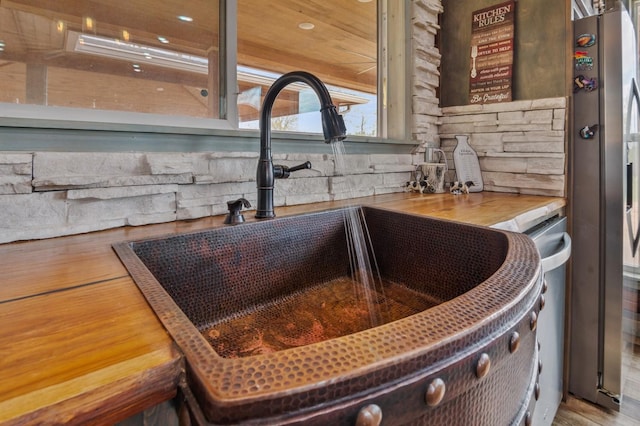 details featuring freestanding refrigerator and a sink