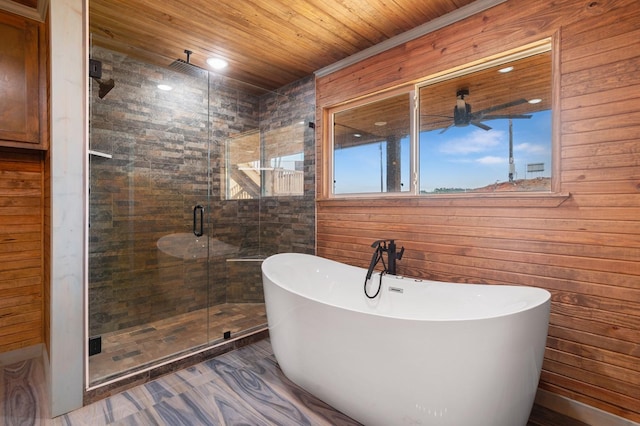 bathroom featuring wooden ceiling, a freestanding bath, a shower stall, and ceiling fan