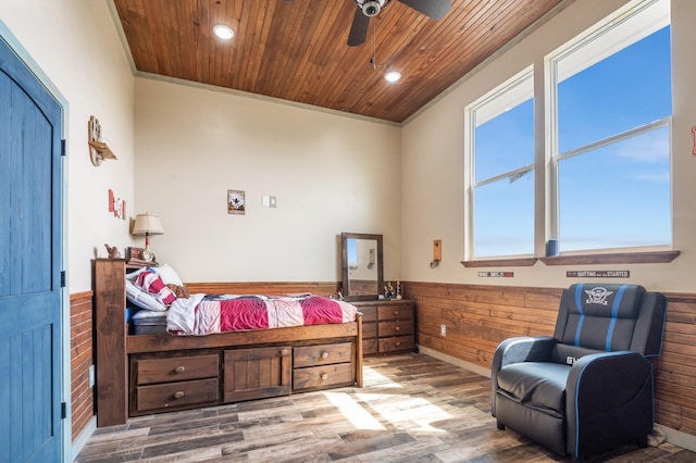 bedroom featuring wood walls, wainscoting, wood finished floors, and wood ceiling